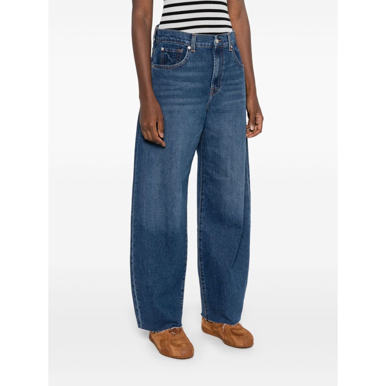 Seven Jeans Blue baggy denim with belt loops and five pockets, featuring a whiskering effect at the thighs, paired with casual shoes.
