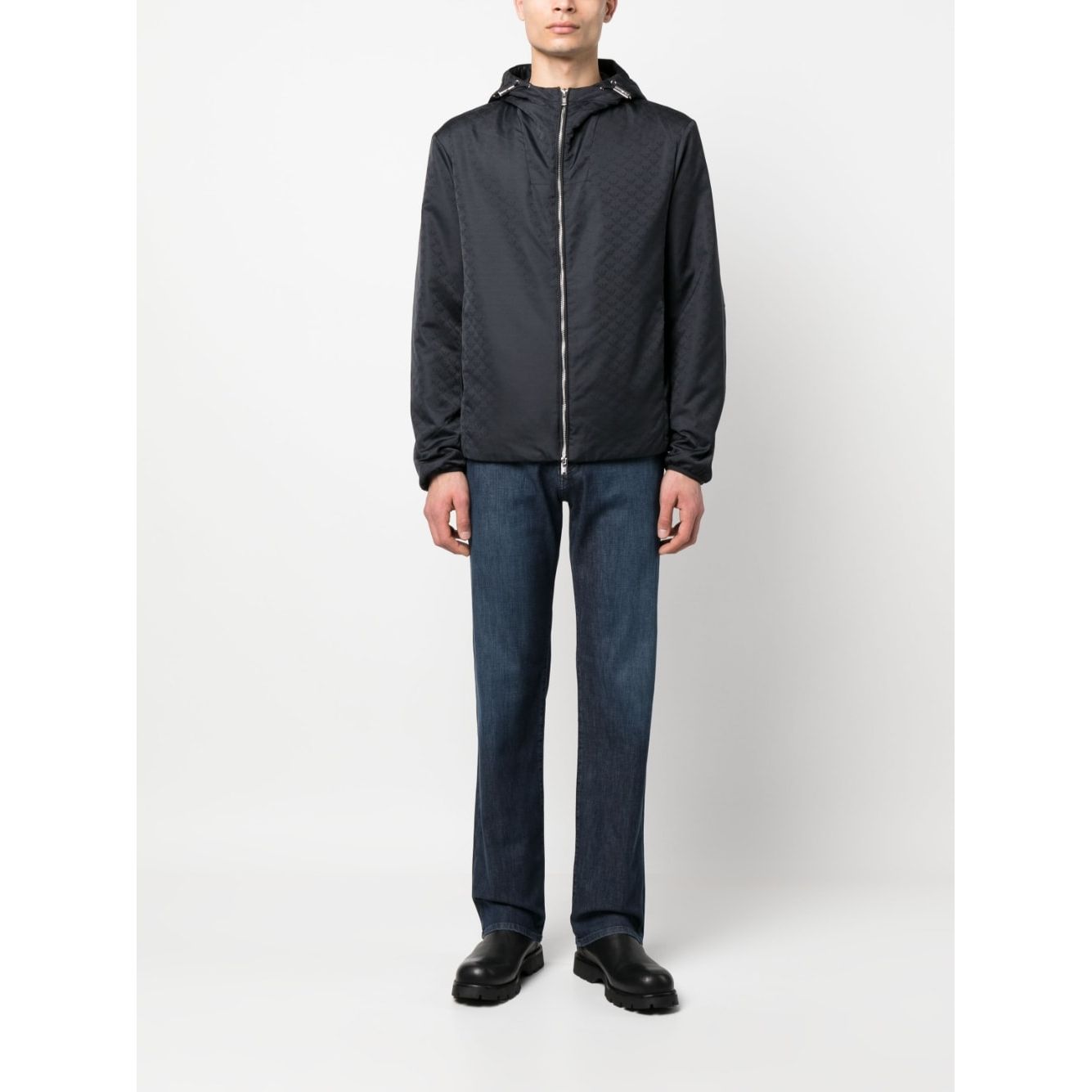 Man wearing Emporio Armani Coats Blue: navy jacket with monogram, silver hardware, drawstring hood, and zip fastening.