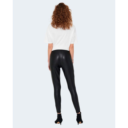 Rear view of model wearing Only Black Polyester Leggings with glossy finish, showcasing comfort and style for casual and evening wear.