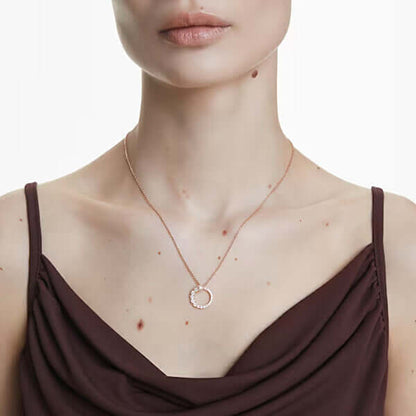 Elegant woman wearing a delicate circular pendant necklace on a thin chain.
