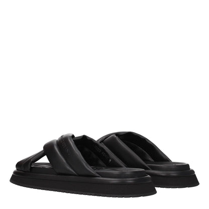 Dolce & Gabbana Black Leather Slippers with side logo, open toe, low heel, rubber sole. Luxury casual footwear for style and comfort.