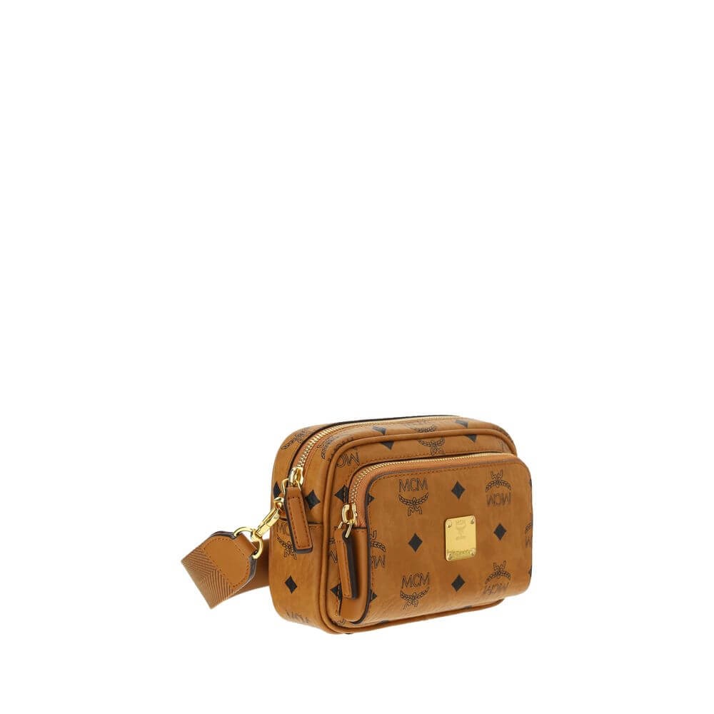MCM Brown Cotton Shoulder Bag with monogram print, gold-tone details, adjustable strap, and top zipper closure.