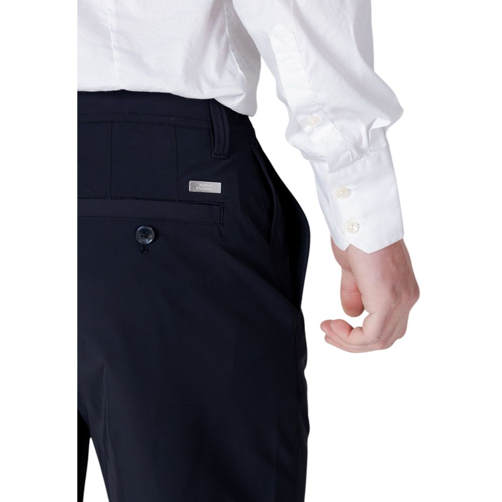 Model wearing Armani Exchange Blue Polyamide Bermuda Shorts with white shirt, showcasing back welt pocket and button detail.