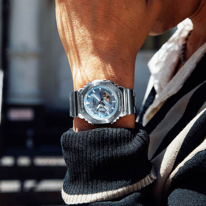 Man wearing CASIO MOD. GM-2110D-2AER watch on wrist, showcasing stylish design and functionality.