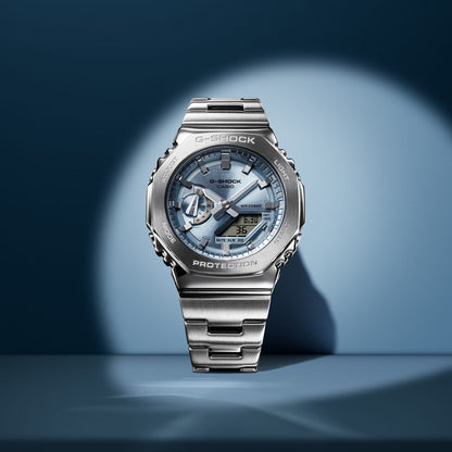 Luxury CASIO MOD. GM-2110D-2AER watch with stainless steel design and blue dial, displaying elegance and modern style against dark background.