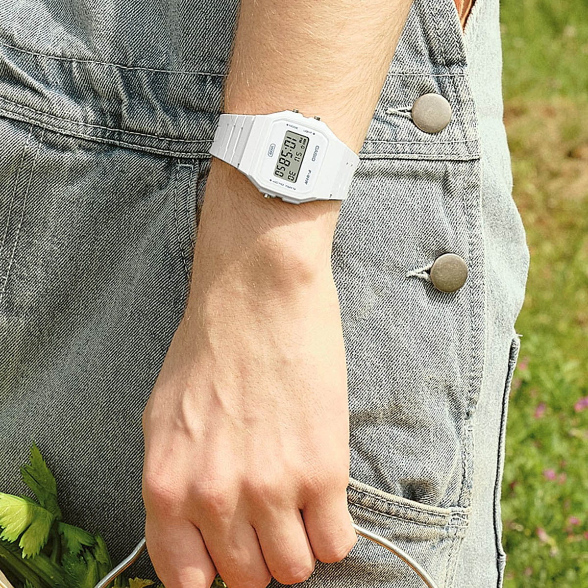 Person wearing CASIO VINTAGE Mod. F-91 BIO RESIN STRAP - WHITE watch outdoors, highlighting its unisex design and multifunction capabilities.