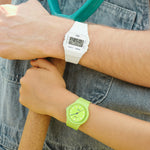 Person wearing CASIO VINTAGE Mod. F-91 BIO RESIN STRAP - WHITE and green watch, showcasing stylish wristwatches in outdoor setting.