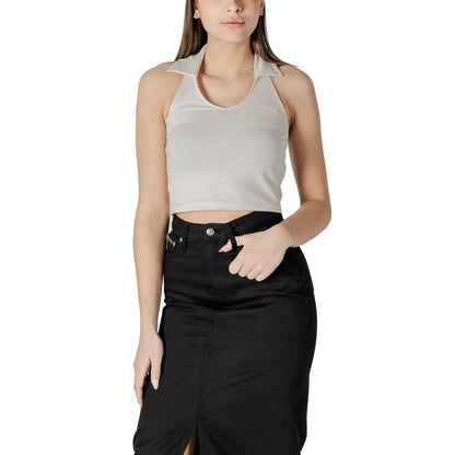 Woman wearing Calvin Klein Jeans Beige Cotton Top with halterneck and polo collar, paired with a black skirt, showcasing casual elegance.
