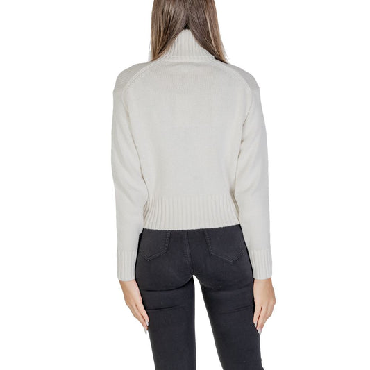 Back view of model wearing Calvin Klein Jeans Cream Cotton Sweater with ribbed turtleneck, emphasizing modern style and iconic CK logo.