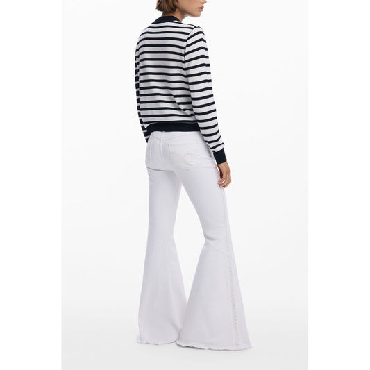 Woman wearing striped sweater and white flared jeans from behind view.