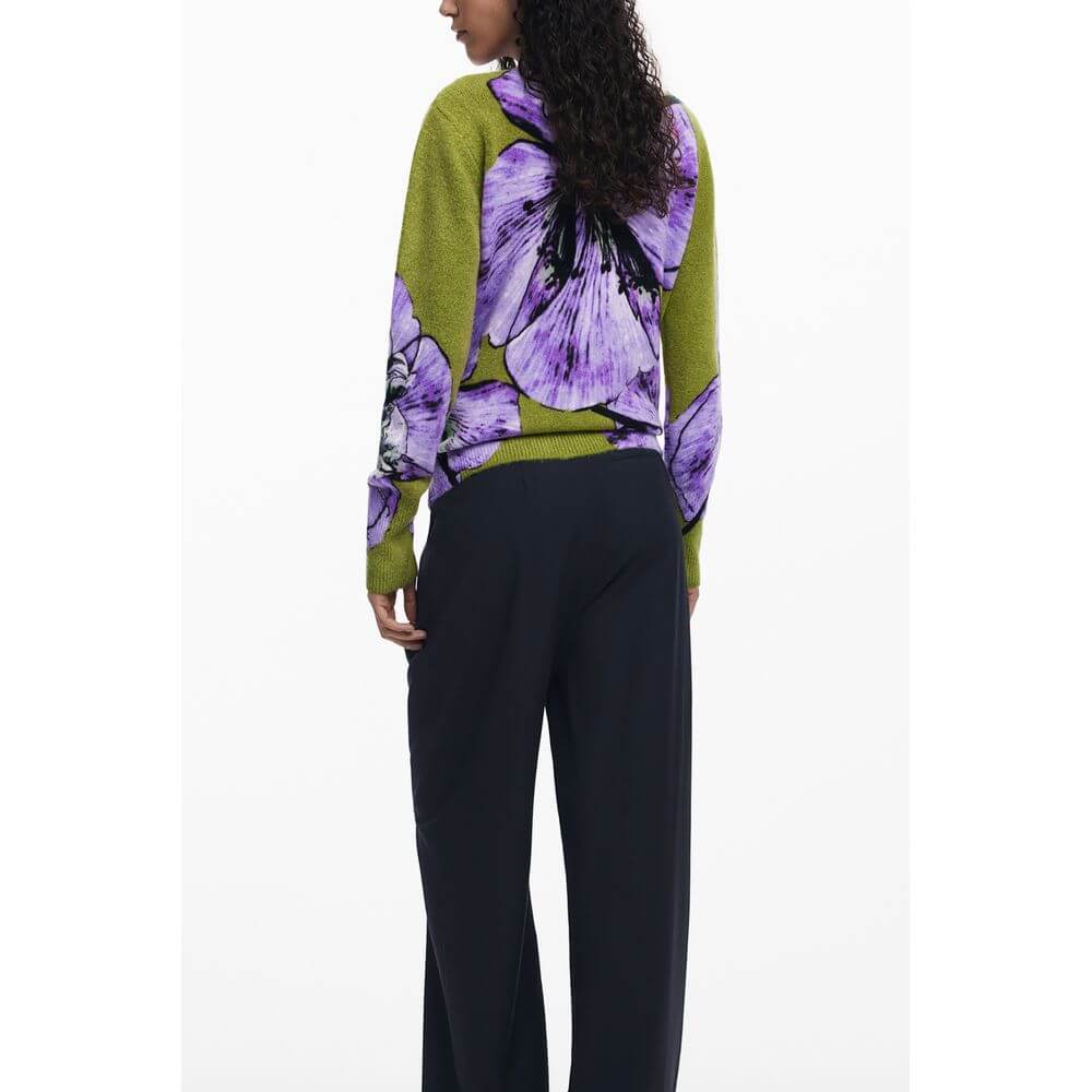 Back view of a model wearing Desigual Purple Elastane Women Sweater featuring bold purple floral patterns, paired with black pants.
