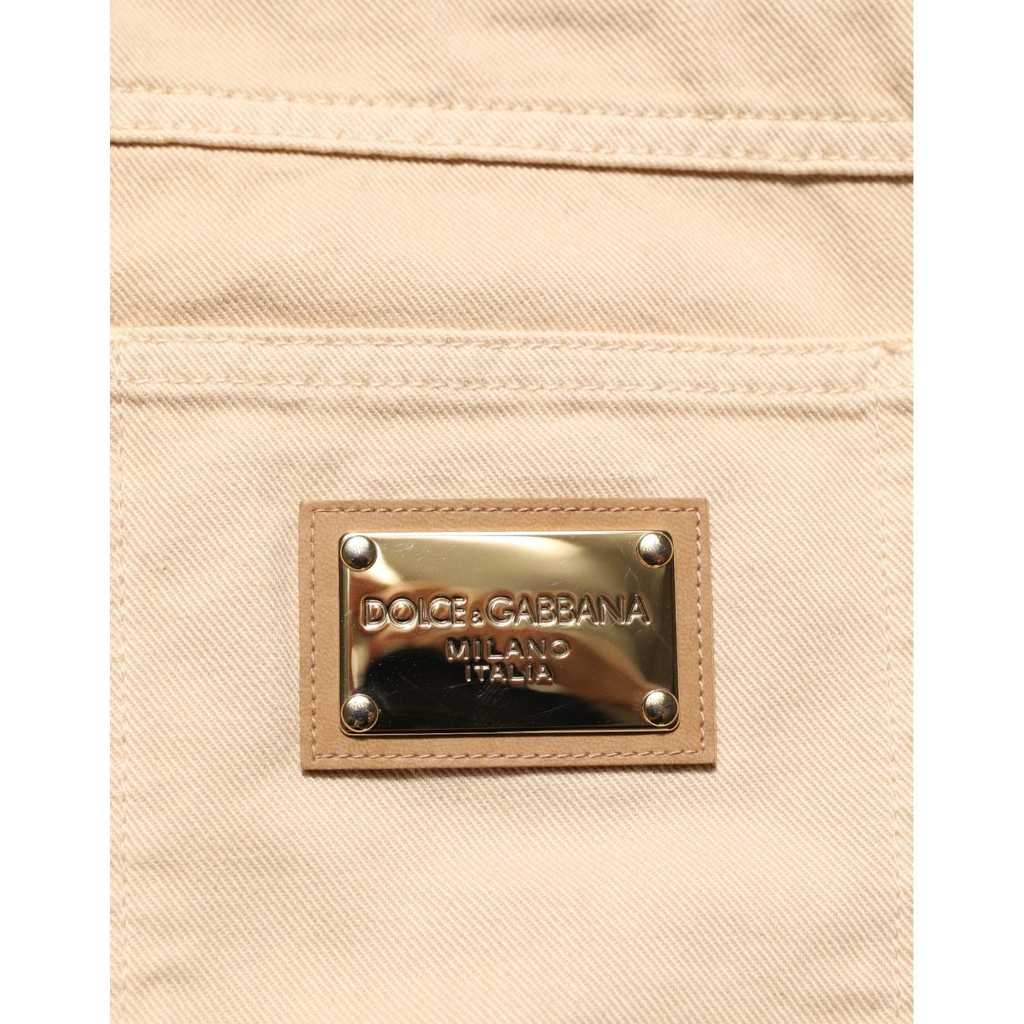 Close-up of Dolce & Gabbana Beige Cotton Skinny Regular Men Denim Jeans with logo patch on back pocket.