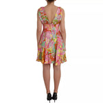 Back view of Dolce & Gabbana Multicolor Floral Silk Flared Mini Dress on model, featuring vibrant floral print and deep V-neck style.