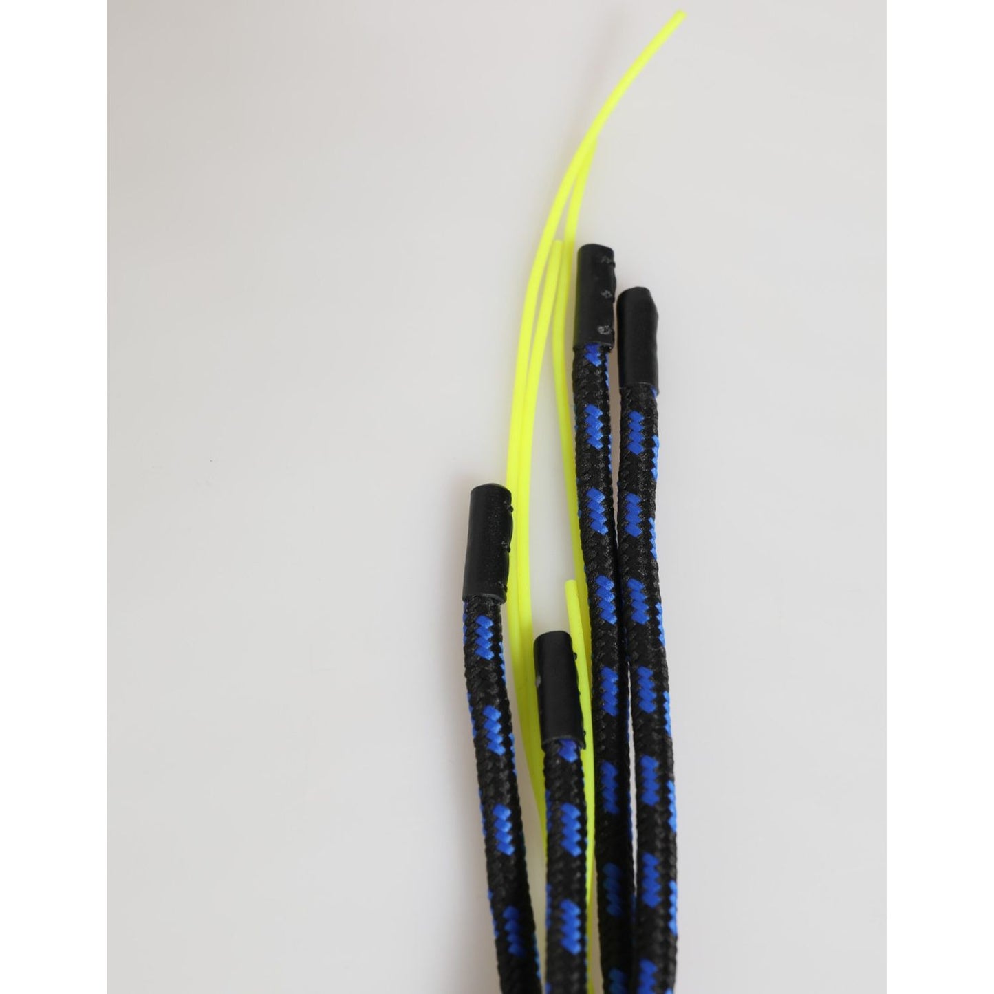 Black and yellow striped ropes with black tips on a neutral background.
