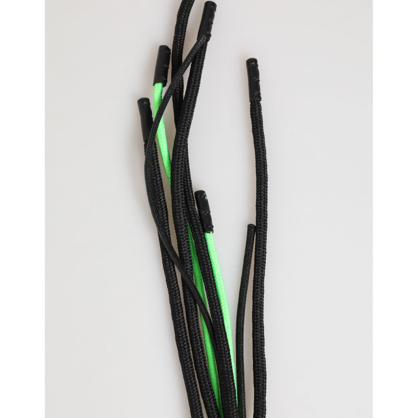 Black and neon green shoelaces on a light background