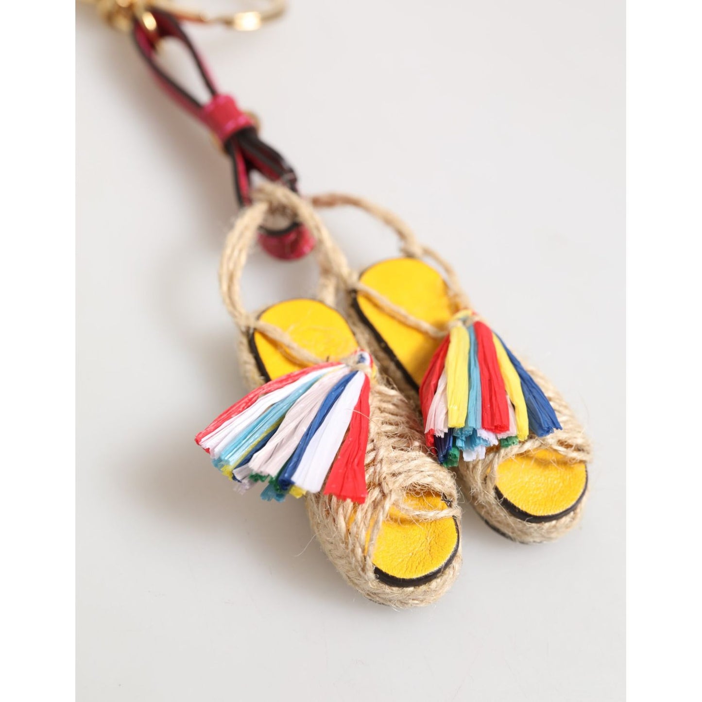 Dolce & Gabbana Red Yellow Mini Espadrille Style Charm Keychain Keyring with colorful tassels on neutral background.
