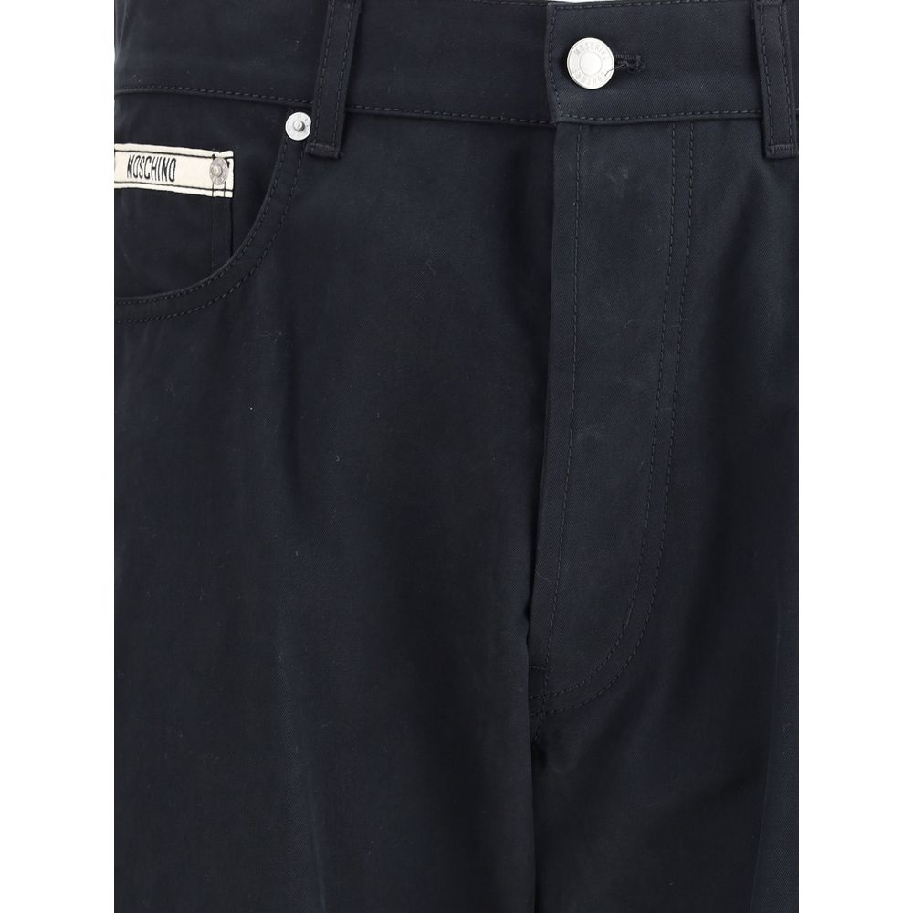 Close-up of Moschino Black Cotton Casual Pants showcasing front patch and zip-button closure.