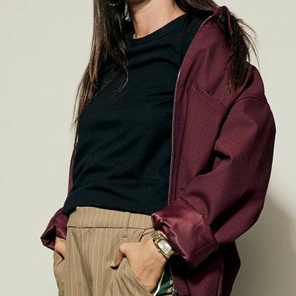 Fashionable woman wearing a burgundy jacket and striped pants, showcasing a stylish NIXON WATCHES Mod. A1441-5324 on her wrist