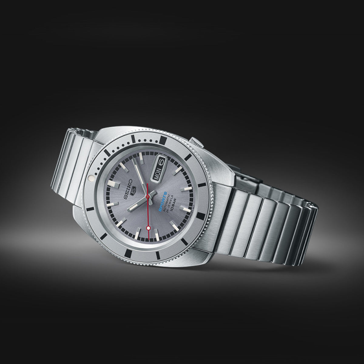 SEIKO 5 Mod. SPORTS Automatic watch with stainless steel bracelet, displaying a sleek design on a dark gradient background.