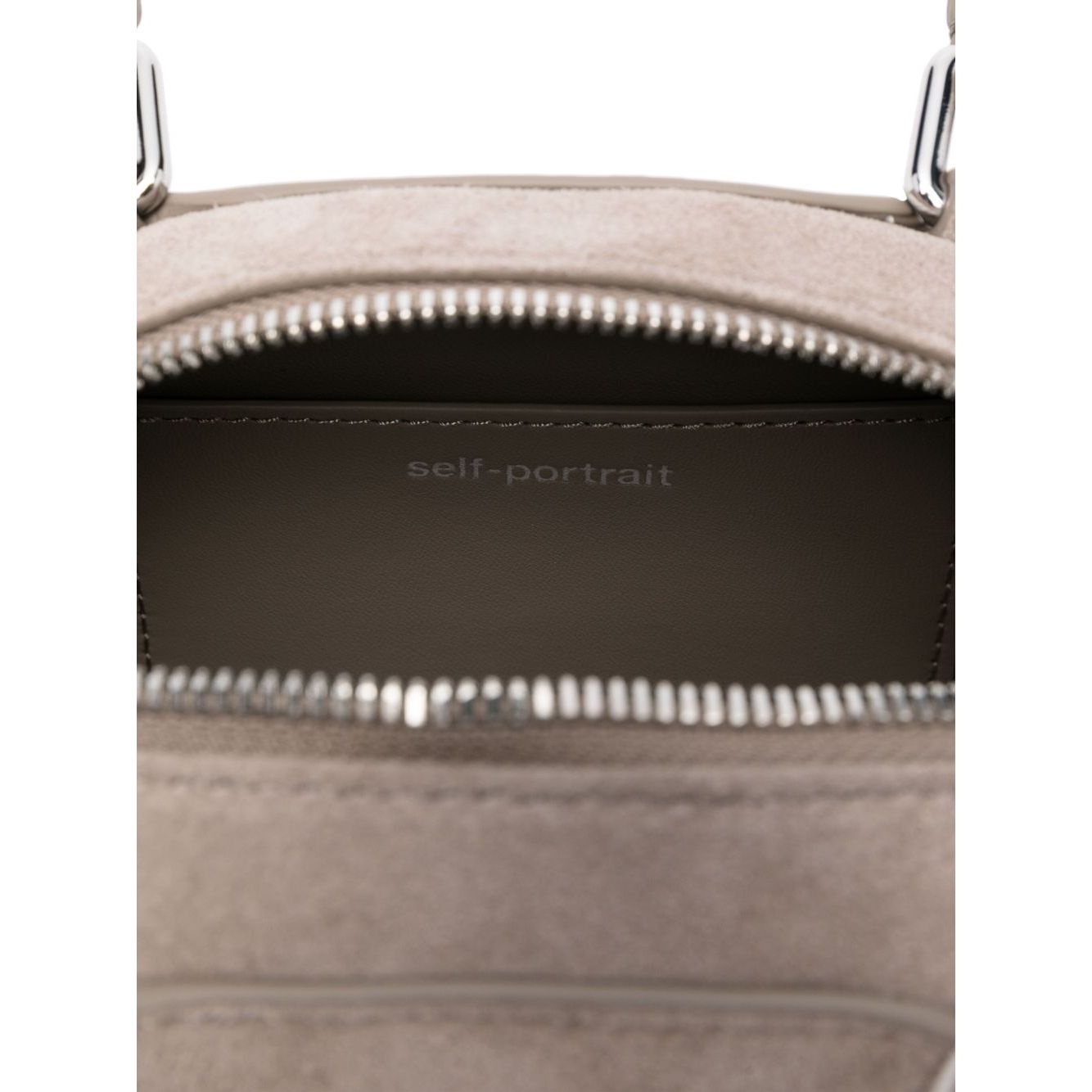 Interior view of grey Self-Portrait Suede mini shoulder bag, showing zip closure and brand logo inside main compartment.
