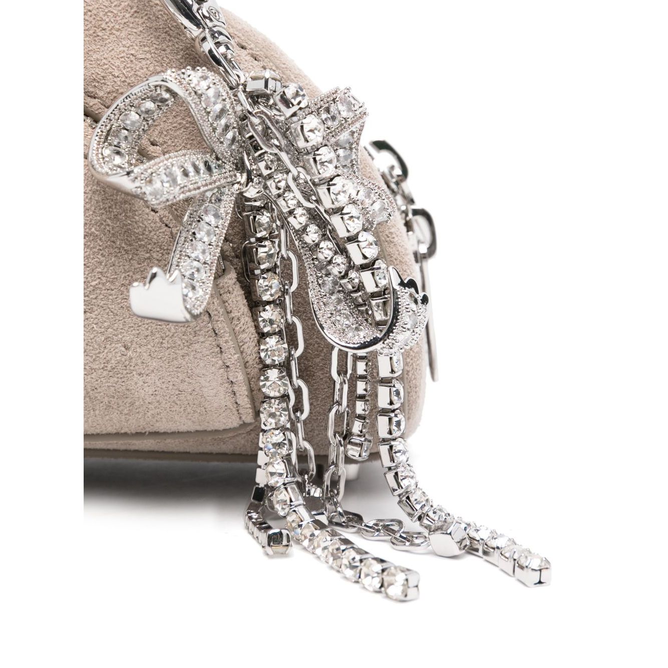 Close-up of Self-Portrait Suede mini shoulder bag with crystal bow detail, showcasing luxurious texture and metallic accents.