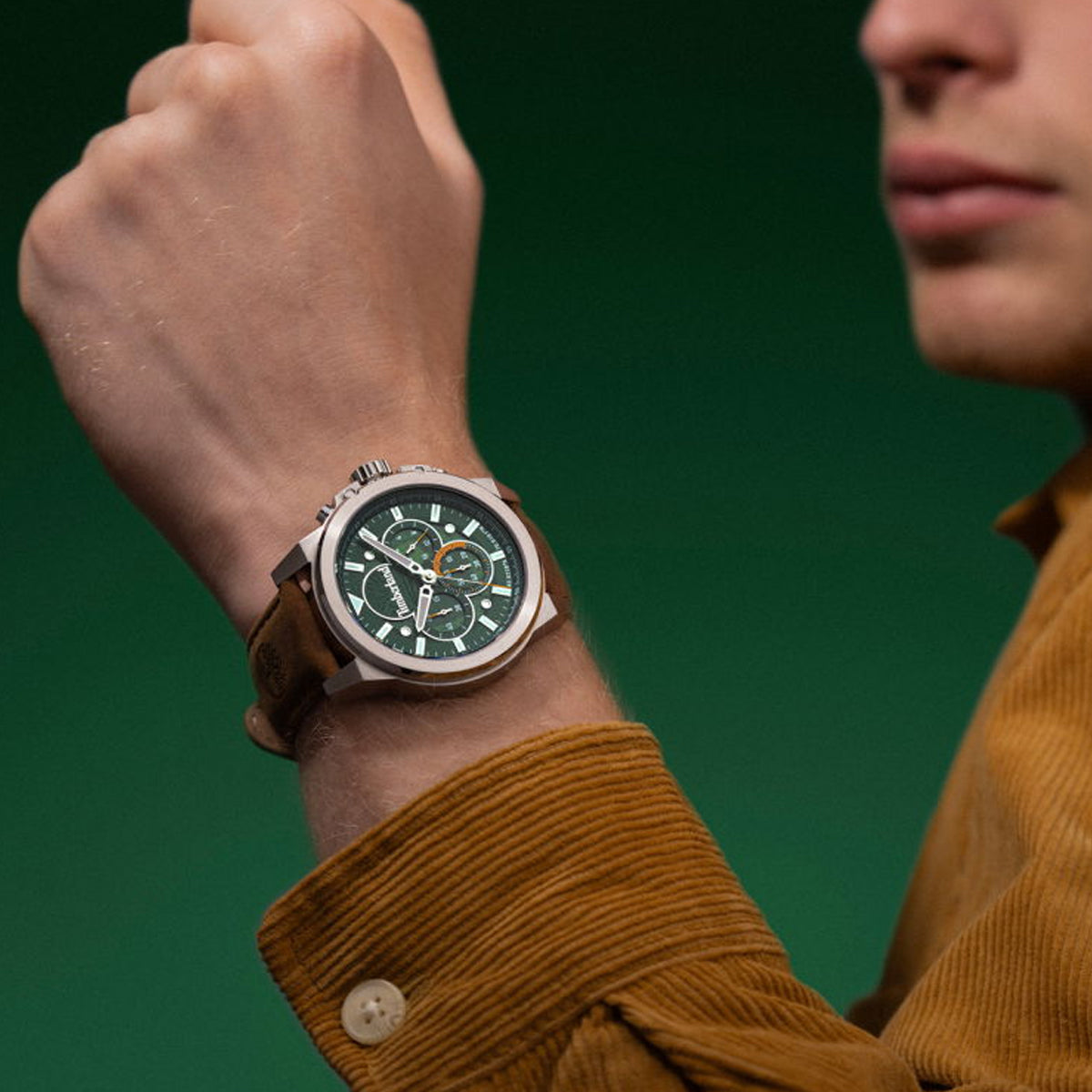 Stylish man wearing a green face watch with a brown strap