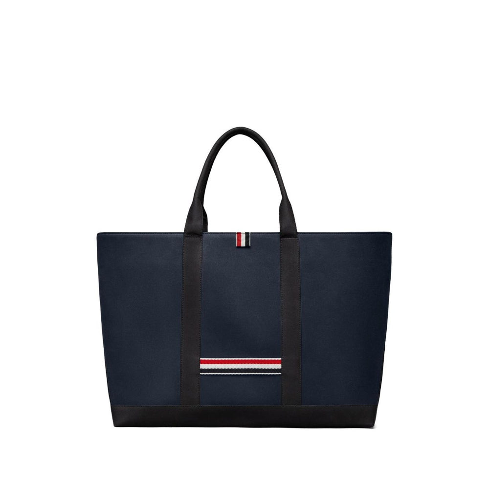Thom Browne Medium drawstring opening tool tote bag in navy blue with RWB stripe, featuring top drawstring fastening and two handles.