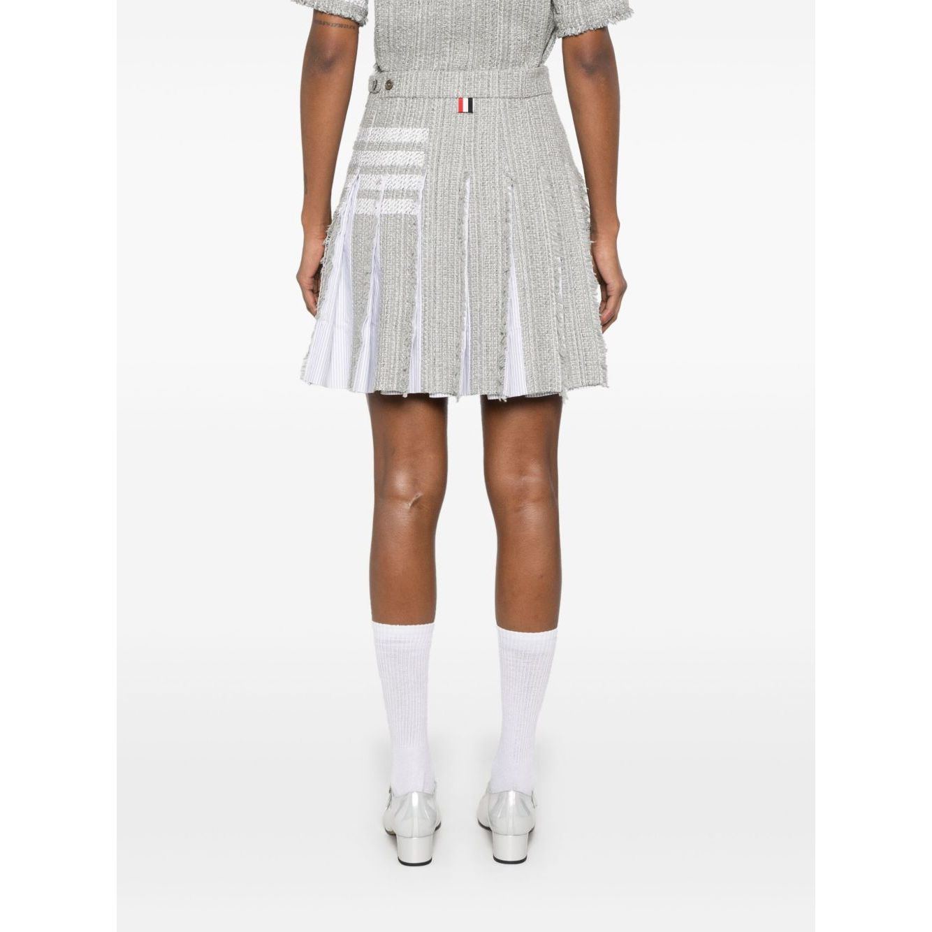 Back view of a grey Thom Browne Skirts Grey with frayed edges, signature 4-Bar stripe, and side button detailing.