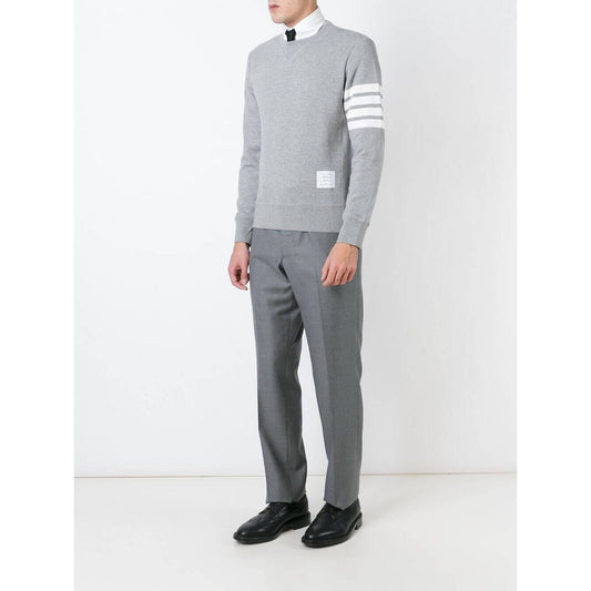 Model wears Thom Browne Sweaters Grey with 4-Bar stripe, ribbed trims, and button side fastening, crafted from loopback cotton jersey.