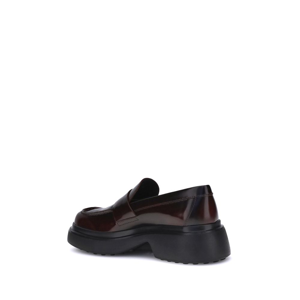 Side view of Tod's Brown Rubber Platform Loafers with patent leather upper and rubber sole, showcasing the logo plaque and rounded toe design.