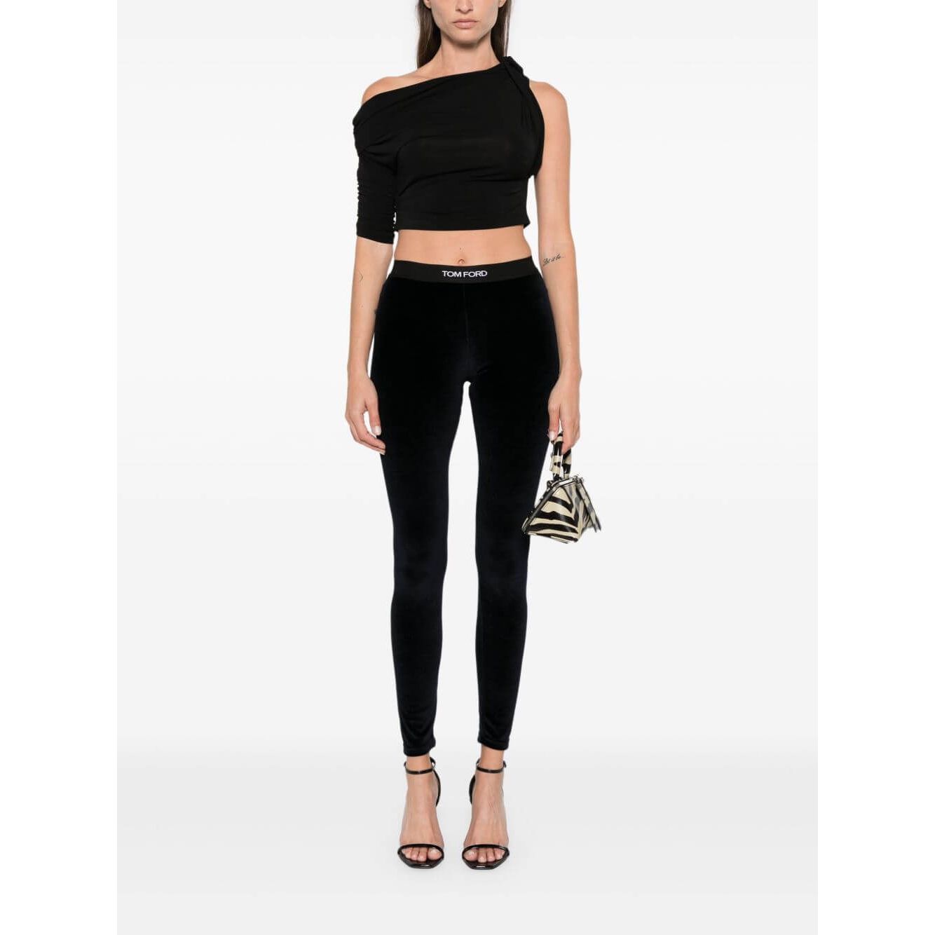 Tom Ford Trousers Blue midnight velvet leggings with logo waistband, model wearing size S, styled with off-shoulder top and handbag.