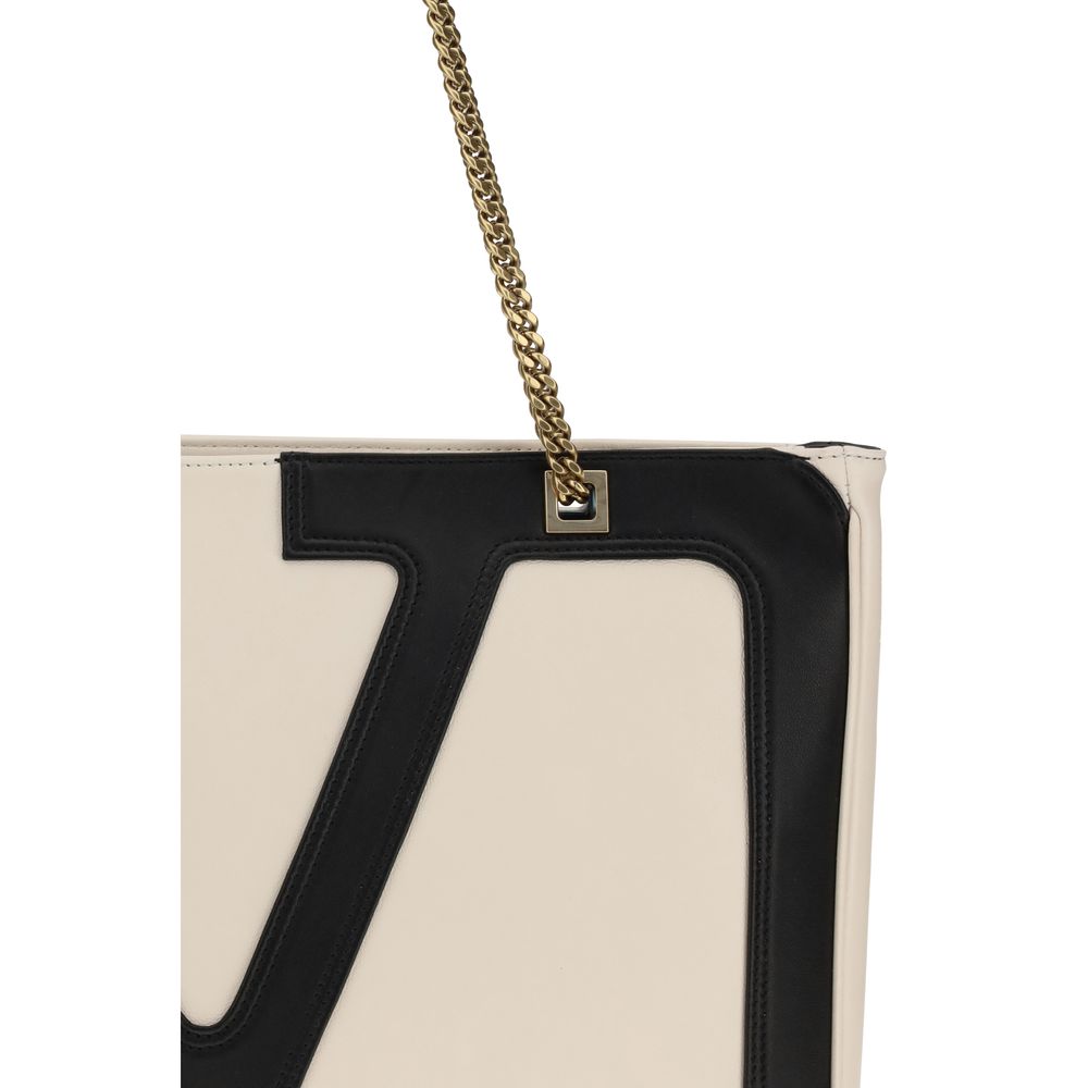 Close-up of Valentino Garavani Cream Calf Leather Bos Taurus Shoulder Bag with VLogo and chain handle detail.