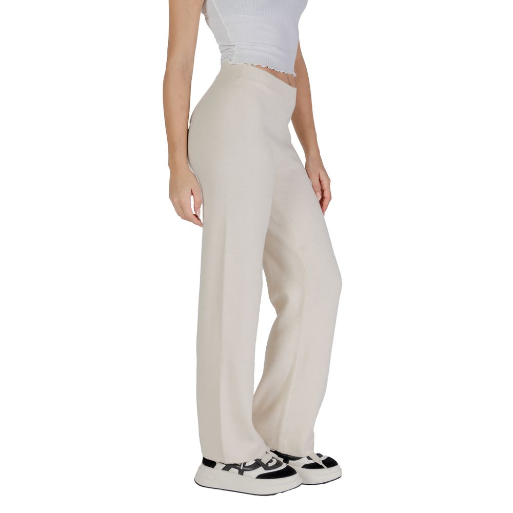 Woman wearing Vero Moda Cream Viscose Pant, wide-leg palazzo style, paired with a white top and sneakers, demonstrating fit and style.