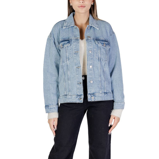Woman wearing Vero Moda Light Blue Cotton Jackets & Coat with oversized denim fit, shirt collar, and front flap pockets.