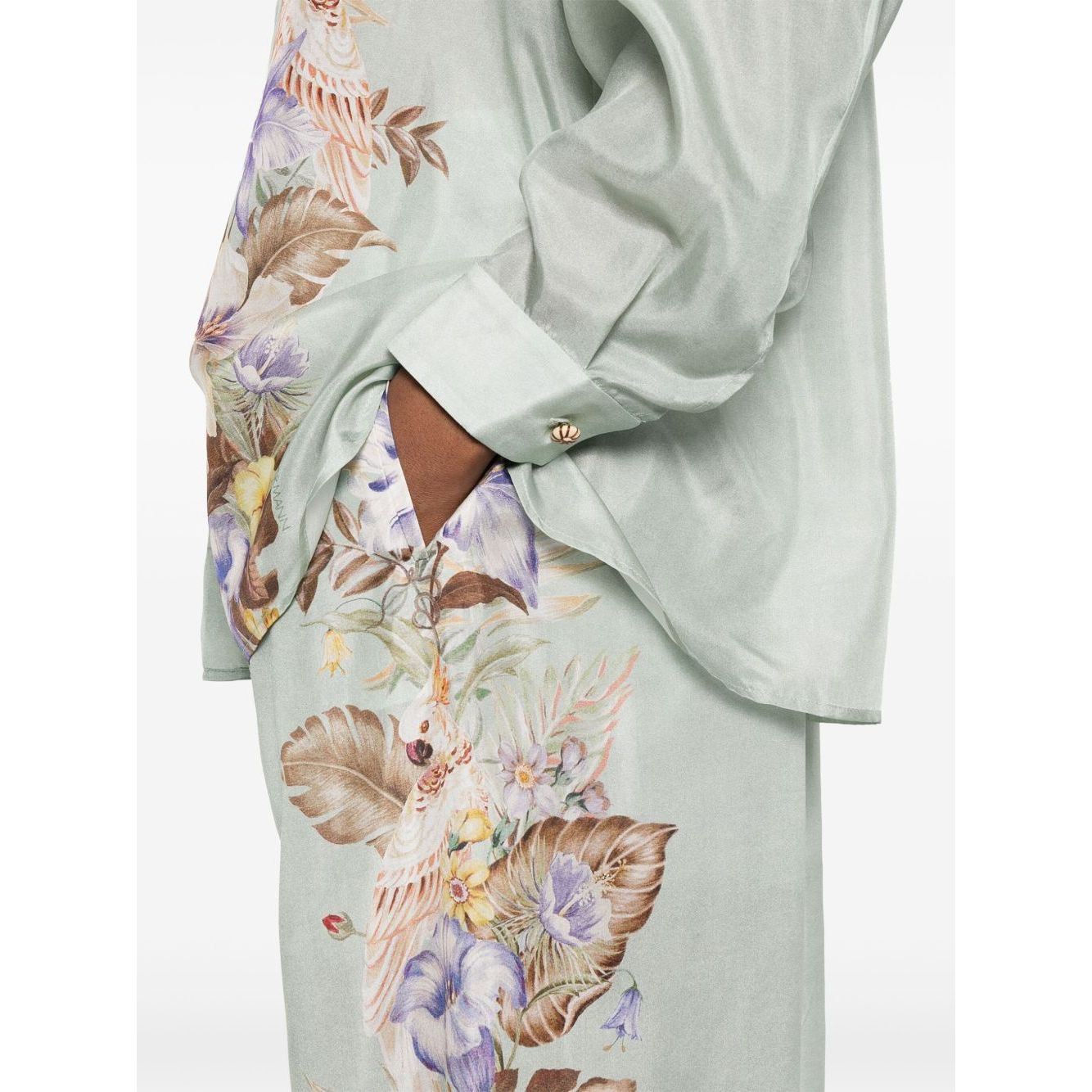 Model wearing Zimmermann Coco trousers in sage green with floral print and elasticated waistband.